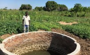 Mr Gerald Action - lead farmer beneficiary of the Nsanje Early Recovery and Resilience Building Project - pictured standing in front of the shallow wells that Concern has rehabilitated with bricks and cement and also treadle pumps and hoses for irrigation of his surrounding crops. Photo: Elias Antoniou / Concern Worldwide