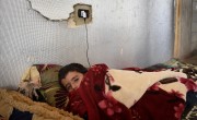 Syrian refugee *Abdel, 7 under a blanket in the garage he and his family are currently living. Photo: Mary Turner