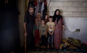Syrian refugee *Dibeh, 41, and her children *Bilal, 10, *Abdel, 7, and *Omar 8, are pictured in the garage where they are currently living. Photograph by Mary Turner