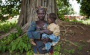 Marie Mbendu (40) with 15-month-old twins Dorcas, in her arms, and Moise, on her back, at Gbandengue Health Facility, which is supported by Concern. Dorcas has recovered from severe acute malnutrition after she was admitted to the clinic nine months ago. But now, Moise is severely malnourished and is receiving treatment. Photographer: Chris de Bode
