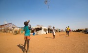 A child flies a home made kite on the streets of Juba's PoC, South Sudan. Photo: Steve De Neef