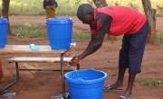 Enika Mussa  practices good hand washing to prevent the spread of Covid-19. He is attending the Concern Consumption (Cash) Support Distribution through he Graduation Programme in Mangochi District, Malawai. Photo: Levy Mwambarulu Kadrab / Concern Worldwide