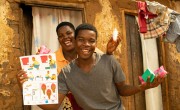 Patricia Moloko with her son George pictured with the soap and Covid-19 fliers they have received from Concern Malawi.