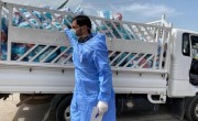 A man in a mask distributes hygiene kits