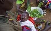 Natalie Wato with her five-week-old son prepares a meal with squash leaves grown from seeds provided by Concern. Photo: Chris de Bode