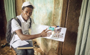 Community health worker Nabie Kargbo explains the importance of clean water to Fullah Sesay in Dwarzack community, Freetown Photographer: Michael Duff