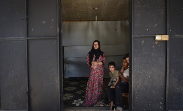 Syrian refugee *Dibeh, 41, and her children *Bilal, 10, *Abdel, 7, and *Omar 8, are pictured in the garage where they are currently living. Photograph by Mary Turner