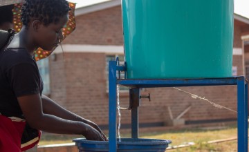 Jessy, washing hands at the hospital's entrance before seeing her patient. Photo: Henry Mhango 