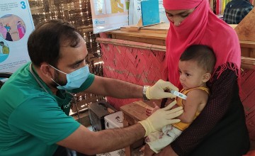 A paramedic is checking the temperature of 8 month old, Arman* in Cox’s Bazar, Bangladesh. Photo: Rajib Kumar Kundu