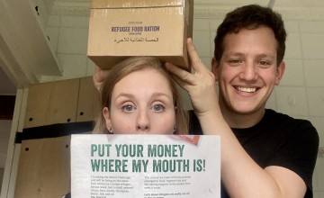 A girl holding a poster and a boy holding the Ration Challenge box