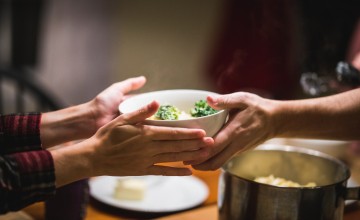 People passing a bowl of food