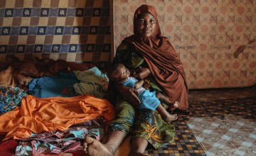 A mother breastfeeds her young baby