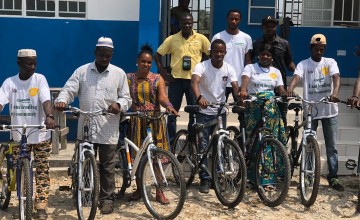A group of traditional healers and influential women stand with bikes