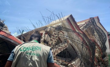 Concern staff observing a fallen building that housed a pharmacy and two apartments. Photo: Makayla Palazzo