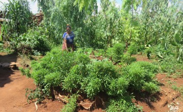 A woman shows off her vegetable garden