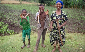 Female Ethiopian farmer with her sons in her field