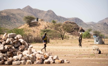 A woman carries a bucket of stones in Milimatatu Village, Kaeris, Turkana County. Photo: Lisa Murray/Concern Worldwide