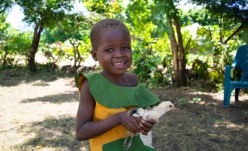 Tamandani with a chicken their family purchased with money from Concern Worldwide. Photo: Chris Gagnon/Concern Worldwide