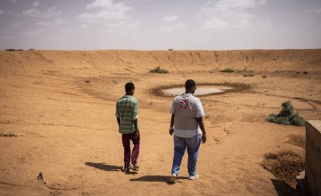 Taysiir Mahamed Abdi and Concern workers Kenneth Oyik and Farhan Abdi Omar, Emergency Project Officer at a nearly dry dam, Qaloocato in Odweine. Photo: Ed Ram/Concern Worldwide