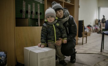 Darina* and her young son, Petro* with their food kit.