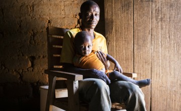 Alain* and baby Christian* sitting in a chair.