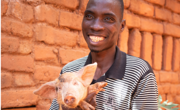 Aubrey holding his piglet and smiling