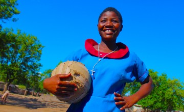 Girl holding football and smiling