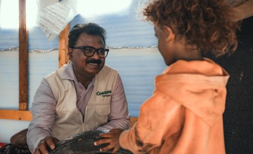 Concern Yemen Country Director Victor Moses chats to a child in in Yemen. The effects of conflict in Yemen has triggered a hunger crisis causing 5 million children under the age of five in need of treatment for acute malnutrition. Photo: Ammar Khalaf/Concern Worldwide