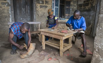 Assa Kamara, Marie Sasay and Isse Conteh fabricating eco stoves from scrap metal.