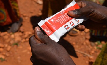 A health worker at Rugombo Health Centre, Cibitoke distributes packets of peanut-paste to mothers whose children are malnourished. In one month alone (August 2017), the clinic has treated 81 cases of severe acute malnutrition and oedema. Photo: Darren Vau