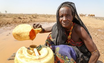Due to the severity of the drought in Kenya, Budha Tura has been forced to gather water from a muddy puddle. Photo: Jennifer Nolan