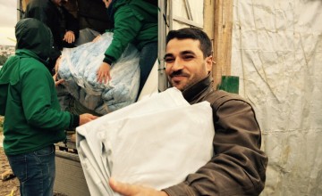 Ahmad el Ezzou receiving Non Food Items in Minyara El Ehssan Informal Settlement, Akkar, Lebanon Photographer: Amanda Ruckel/January 2015/ Lebanon.jpg 