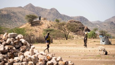 A woman carries a bucket of stones in Milimatatu Village, Kaeris, Turkana County. Photo: Lisa Murray/Concern Worldwide