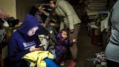 A young person looks through their phone in Lviv