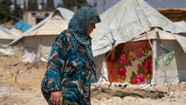 Shahinaz* walks through a camp in north-west Syria on 22 June 2023. As part of Concern Worldwide’s response to the Syria-Turkey earthquake, cash assistance is distributed to displaced families living in camps and temporary shelters to meet their immediate basic needs. After an informational session, each household receives a cash voucher at the distribution point.