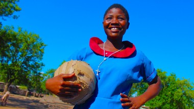 Girl holding football and smiling