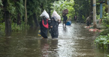Women walk through flooded streets