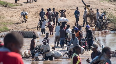 People wade across a river in flood near Nhamatanda, Mozambique. Cyclone Idai has disrupted infrastructure across the country, impacting livelihoods and hampering aid efforts. Photo: Tommy Trenchard / Concern Worldwide