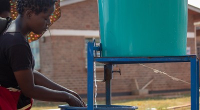 Jessy, washing hands at the hospital's entrance before seeing her patient. Photo: Henry Mhango 