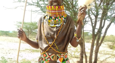 A woman in bright colours smiles at the camera