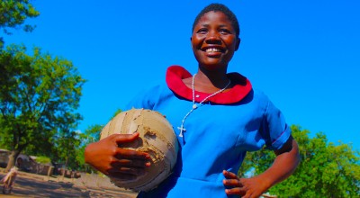 Girl holding football and smiling