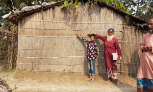 Community members in Vati Kapasia, Kapasia Union, Sundarganj, Bangladesh show the level of the flood water from the 2019 monsoon on their home. Photo: Finola Mohan / Concern Worldwide.