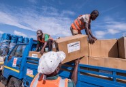 Workers unload kitchen kits from a truck at a distribution in Ndeja, Mozambique, which was hard hit by cyclone Idai in March 2019. Photo: Tommy Trenchard / Concern Worldwide
